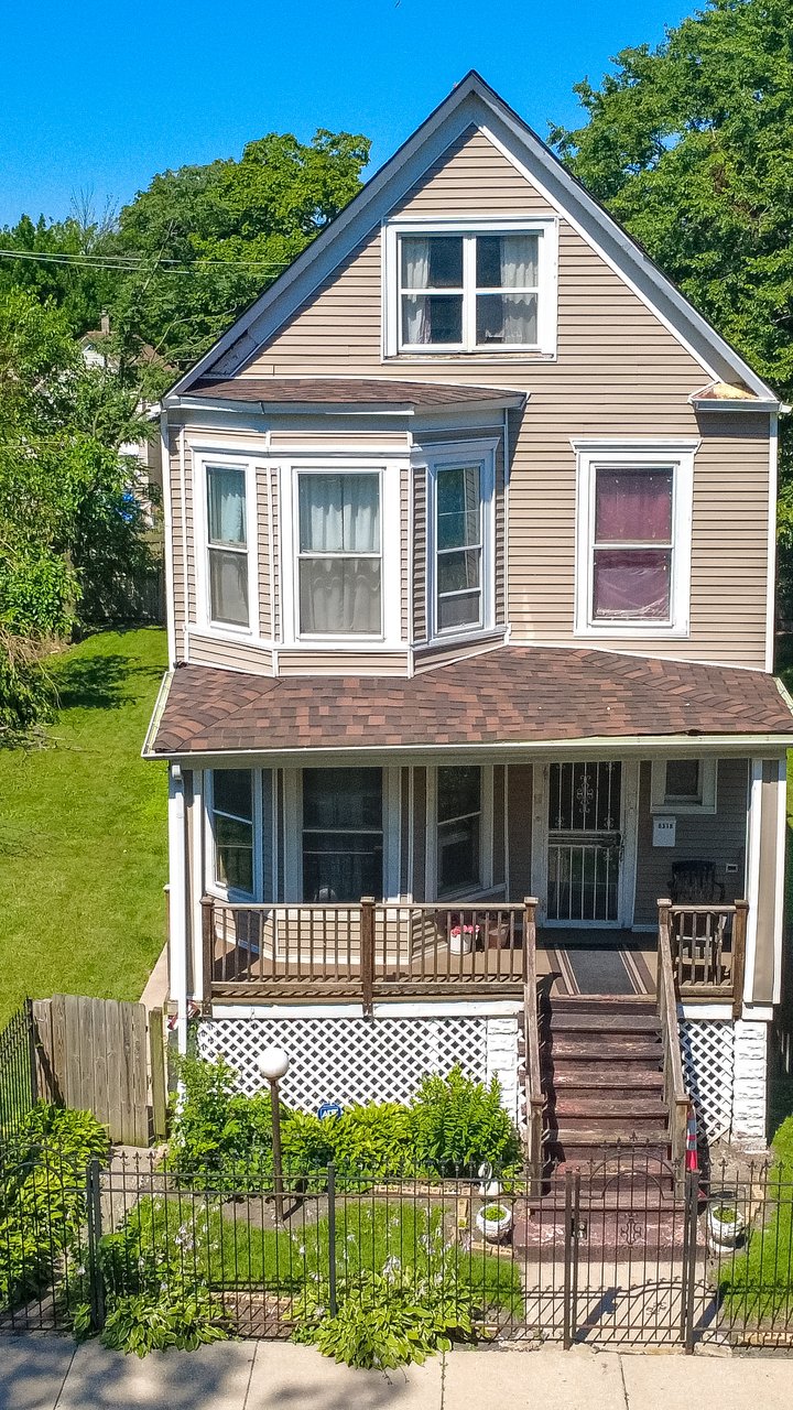 Drone aerial of a two-story residential home with a front porch